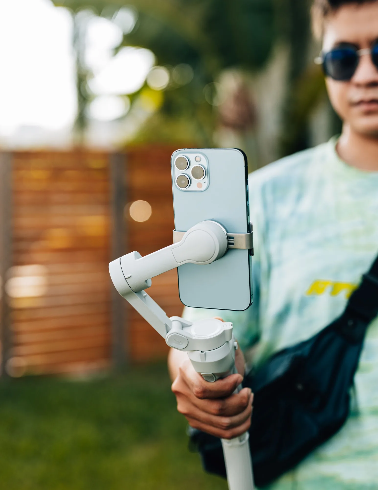 Creator filming with an iPhone on a handheld grip